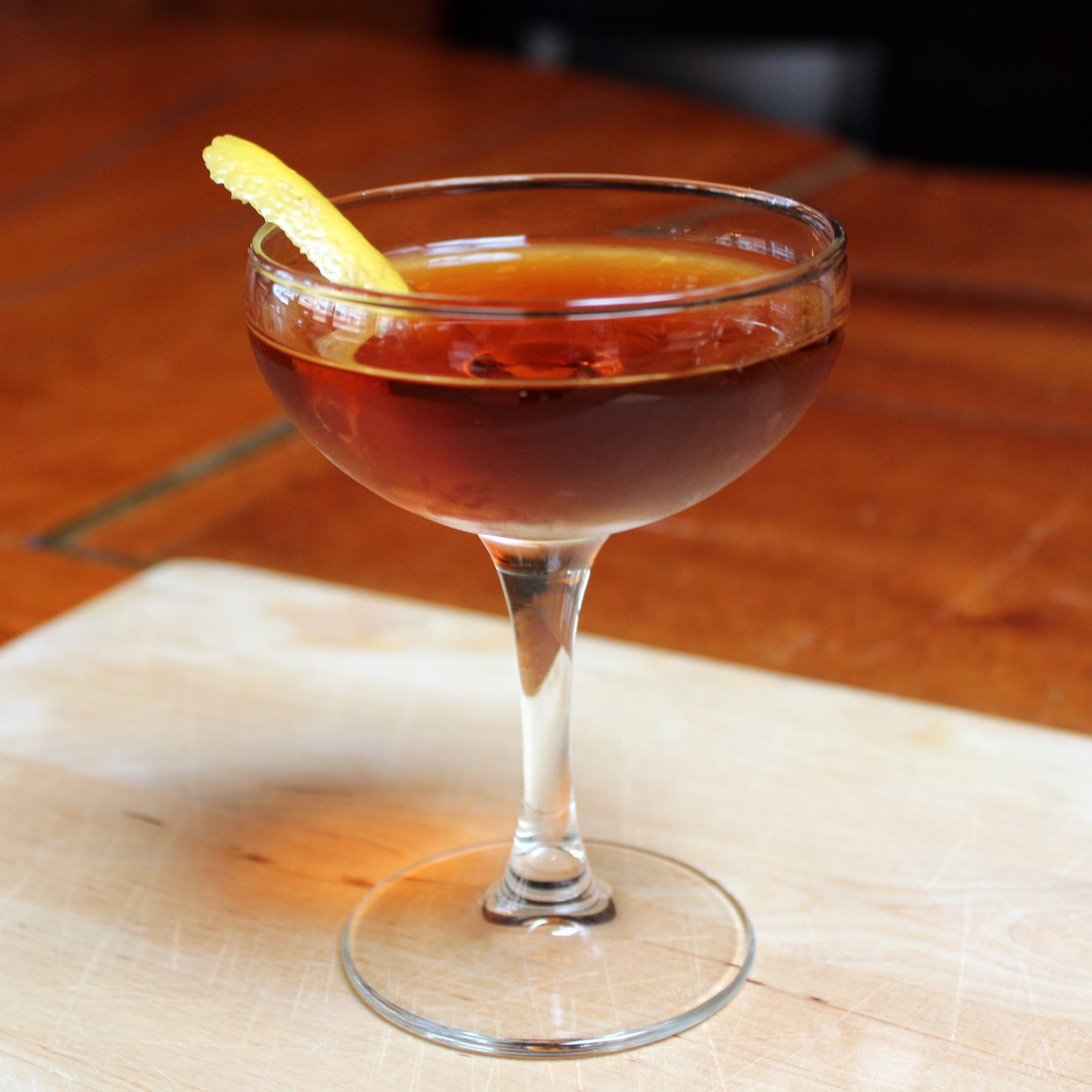 A Martinez in a coupe, amber-red, with a citrus peel